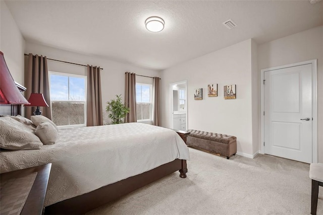 bedroom featuring carpet flooring, visible vents, baseboards, and ensuite bathroom