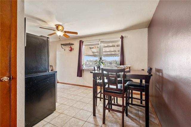 dining area featuring light tile patterned floors, baseboards, and a ceiling fan