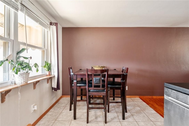 dining area featuring light tile patterned floors and baseboards