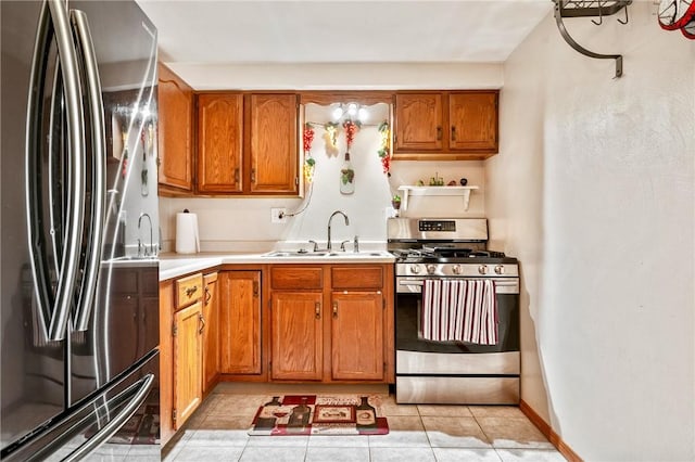 kitchen with stainless steel appliances, a sink, light countertops, and brown cabinets