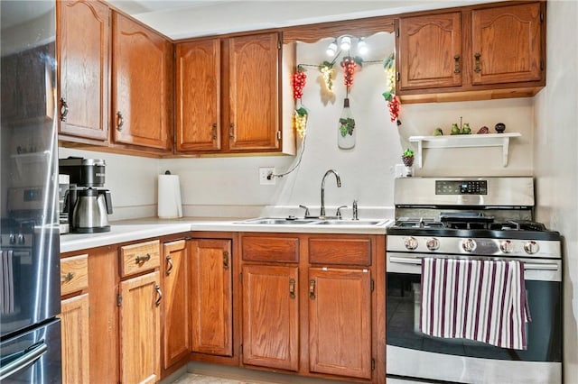 kitchen with stainless steel appliances, brown cabinetry, light countertops, and a sink