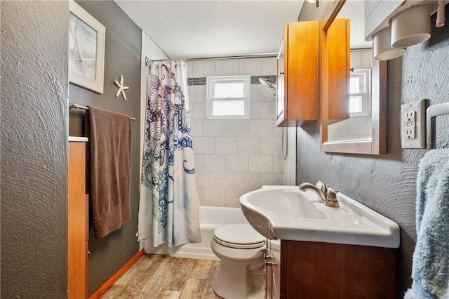 bathroom with toilet, shower / bath combo with shower curtain, wood finished floors, and vanity