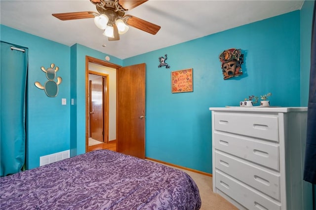 bedroom featuring a ceiling fan, light colored carpet, visible vents, and baseboards