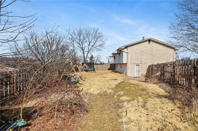 view of yard with fence and a playground