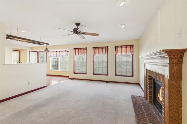 unfurnished living room featuring a wealth of natural light, carpet, and a fireplace