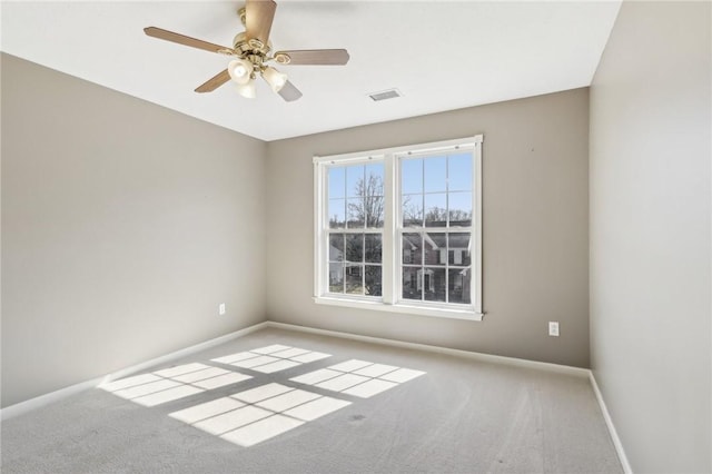 empty room with baseboards, visible vents, ceiling fan, and carpet flooring