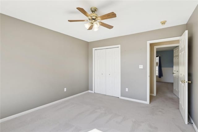 unfurnished bedroom featuring baseboards, a closet, and light colored carpet