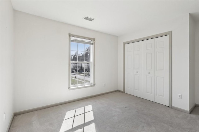 unfurnished bedroom with baseboards, visible vents, and carpet flooring