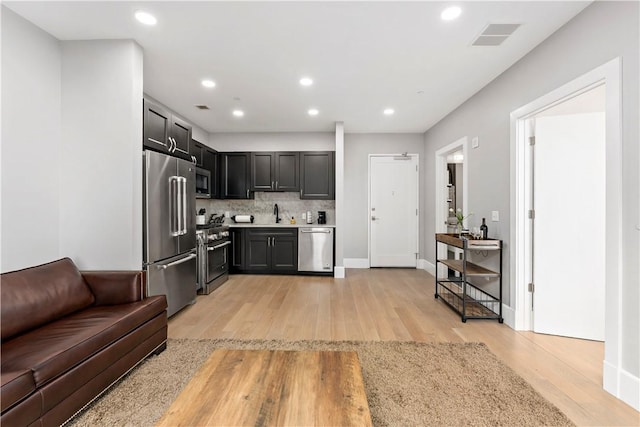 kitchen with light wood-type flooring, visible vents, high end appliances, and light countertops