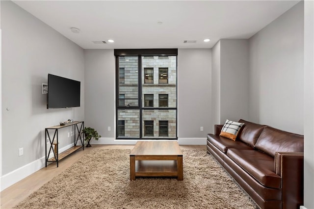 living room featuring recessed lighting, baseboards, and wood finished floors