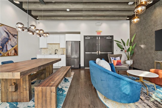 interior space featuring wallpapered walls, baseboards, dark wood-style floors, and beam ceiling