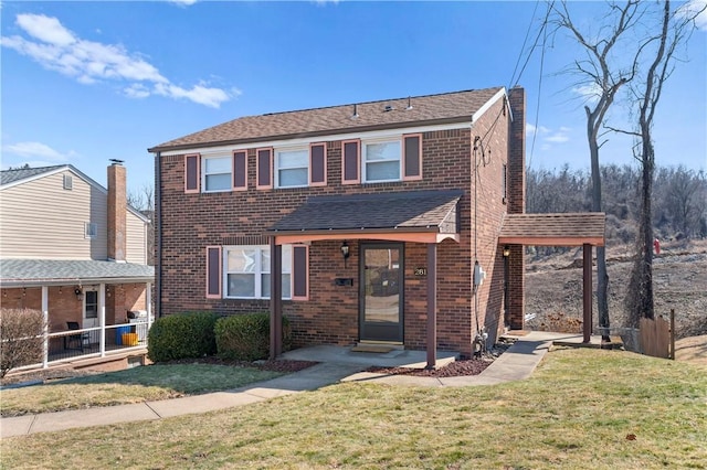 view of front of property featuring a front yard, brick siding, a chimney, and roof with shingles