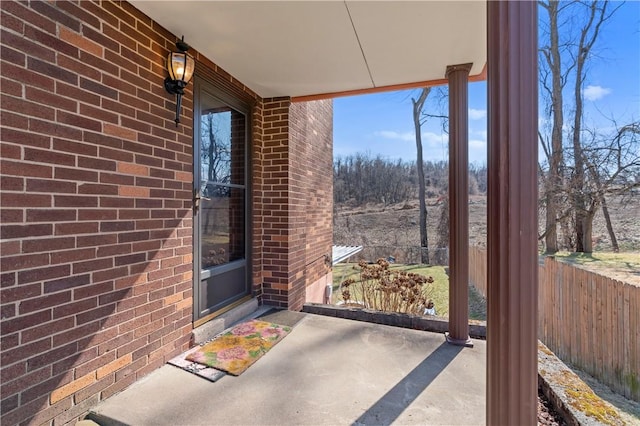 exterior space featuring brick siding and fence