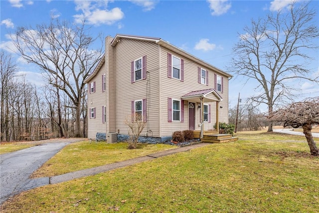 view of front of home with aphalt driveway and a front lawn