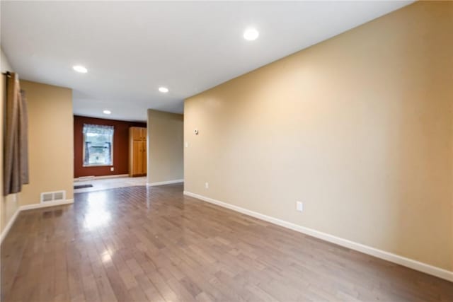 unfurnished room with baseboards, visible vents, wood finished floors, and recessed lighting