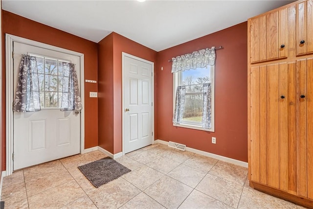 entryway with visible vents, baseboards, and light tile patterned floors