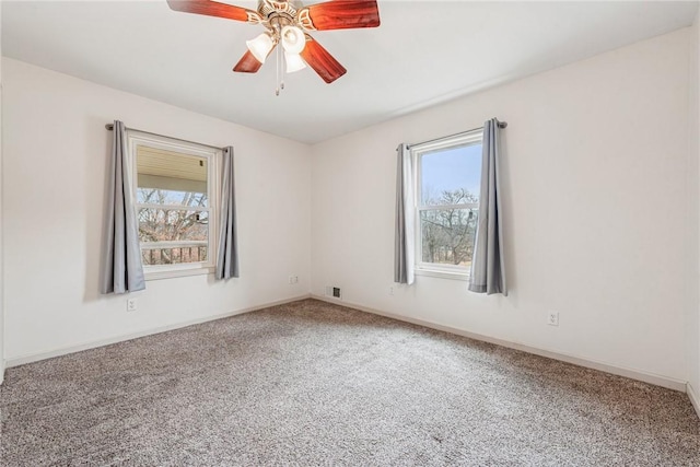 carpeted empty room with a ceiling fan and baseboards