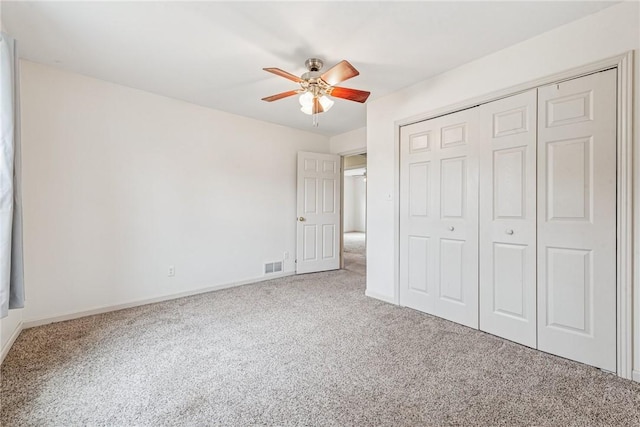 unfurnished bedroom with carpet floors, baseboards, visible vents, and a closet