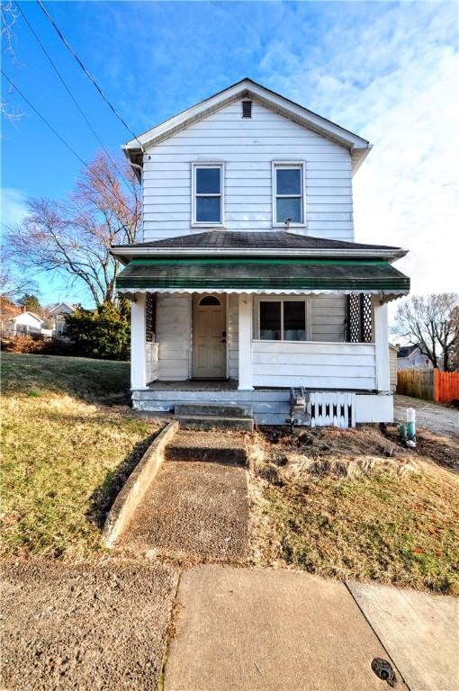 view of front of home featuring fence, a porch, and a front yard