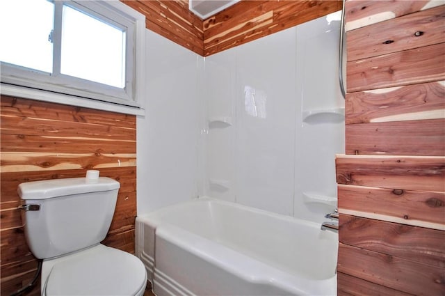 full bath with toilet and wooden walls