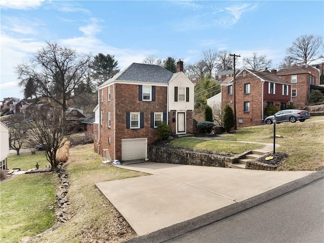 view of front of property featuring a front yard, a chimney, concrete driveway, and brick siding