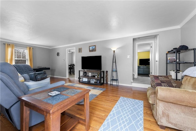 living room with light wood-style floors, baseboards, and ornamental molding