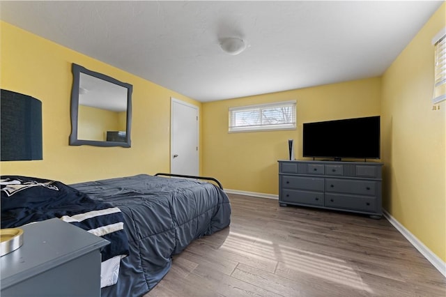 bedroom with baseboards and wood finished floors