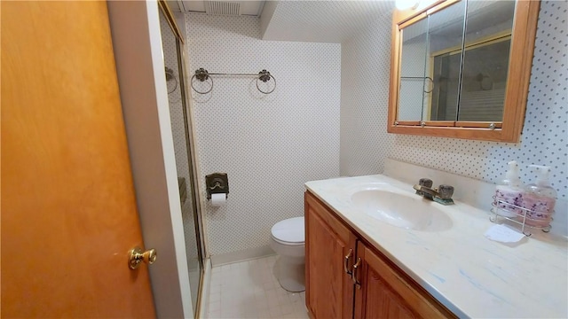 bathroom featuring a shower, vanity, toilet, and wallpapered walls