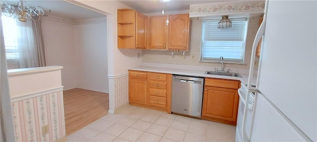 kitchen featuring freestanding refrigerator, light countertops, stainless steel dishwasher, open shelves, and a sink