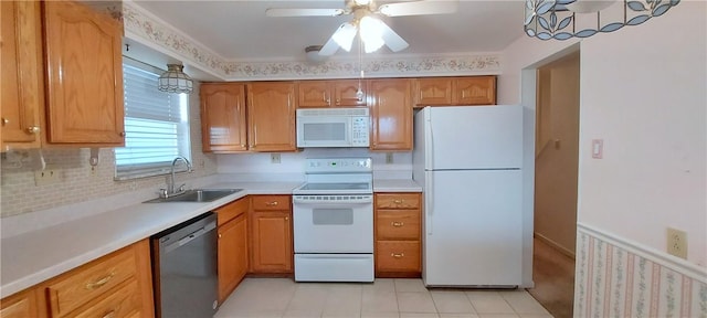 kitchen with ceiling fan, white appliances, a sink, light countertops, and brown cabinetry