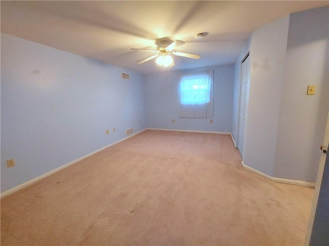 spare room featuring visible vents, light carpet, and baseboards