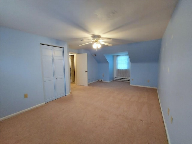 additional living space with light carpet, baseboard heating, a ceiling fan, and baseboards