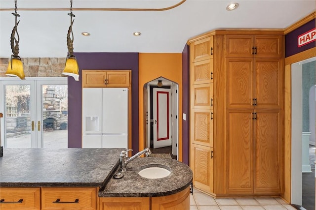 kitchen featuring pendant lighting, a sink, dark countertops, white refrigerator with ice dispenser, and recessed lighting