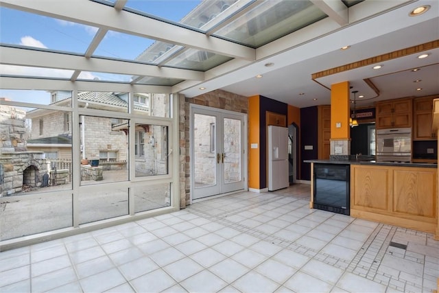 kitchen featuring dark countertops, beverage cooler, recessed lighting, french doors, and white refrigerator with ice dispenser