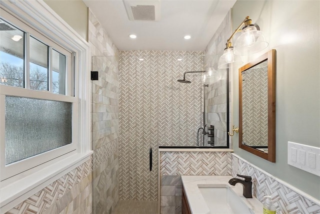 full bath featuring visible vents, a shower stall, tile walls, recessed lighting, and vanity