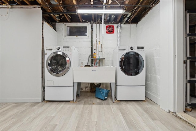 laundry area with laundry area, wood finished floors, and washing machine and dryer