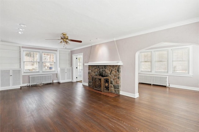 unfurnished living room with ornamental molding, radiator heating unit, baseboards, and wood finished floors