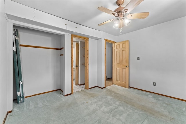 unfurnished bedroom featuring light carpet, a closet, baseboards, and a ceiling fan