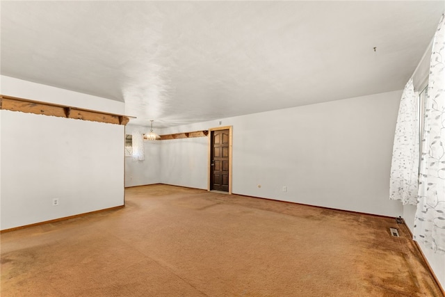 unfurnished room with carpet flooring, visible vents, and baseboards