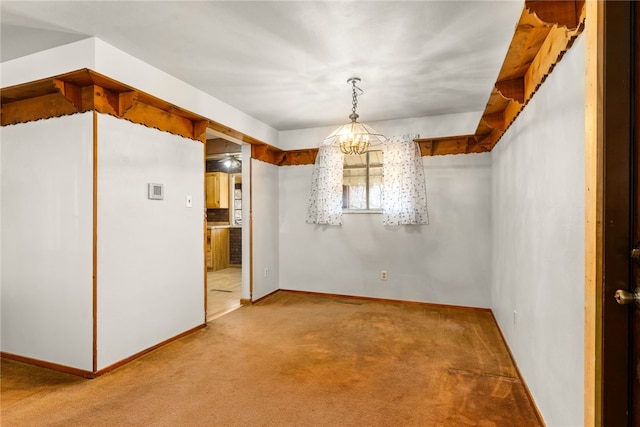 unfurnished dining area featuring carpet, a chandelier, and baseboards