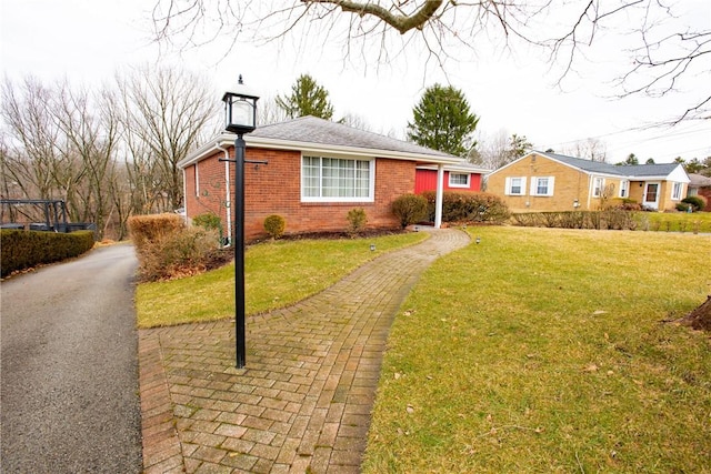 view of front of property featuring a front lawn and brick siding