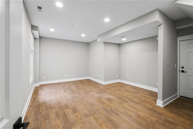 below grade area with light wood finished floors, baseboards, visible vents, and recessed lighting