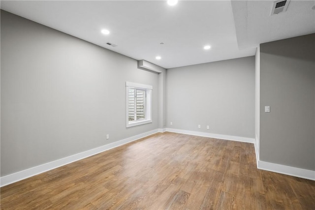 unfurnished room with recessed lighting, wood finished floors, visible vents, and baseboards