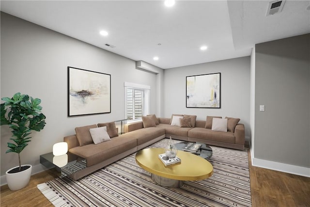 living room with baseboards, wood finished floors, visible vents, and recessed lighting