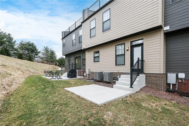 rear view of house featuring a yard, a patio, and central air condition unit