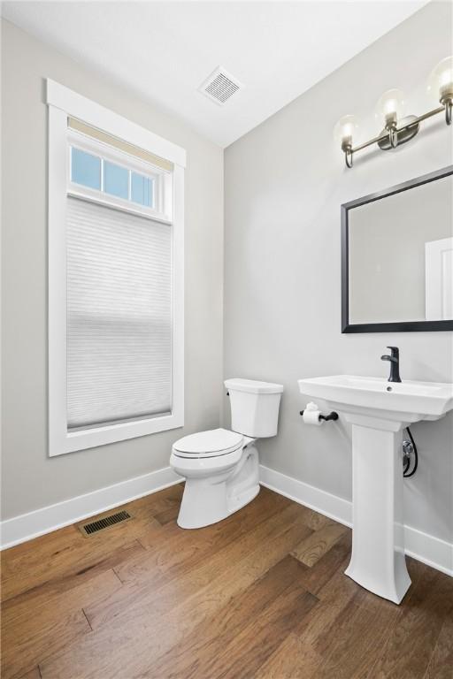 bathroom featuring visible vents, toilet, and wood finished floors