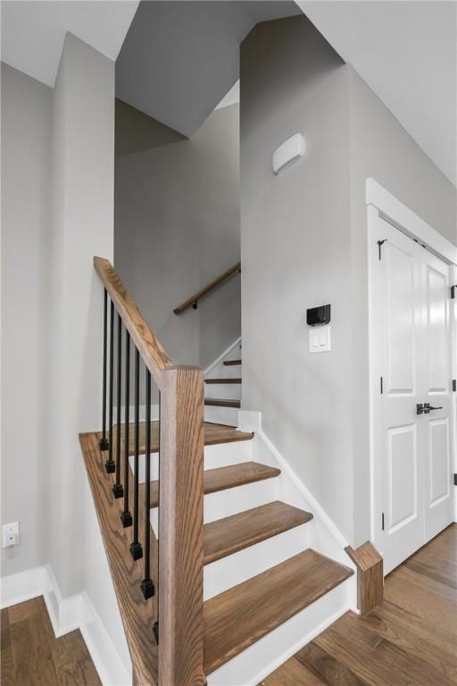 stairs featuring wood finished floors and baseboards