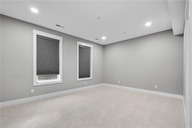 unfurnished room with recessed lighting, light carpet, visible vents, and baseboards