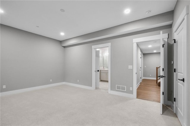 interior space featuring recessed lighting, light carpet, visible vents, baseboards, and ensuite bath