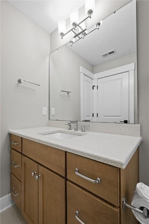 bathroom featuring tile patterned floors, baseboards, visible vents, and vanity